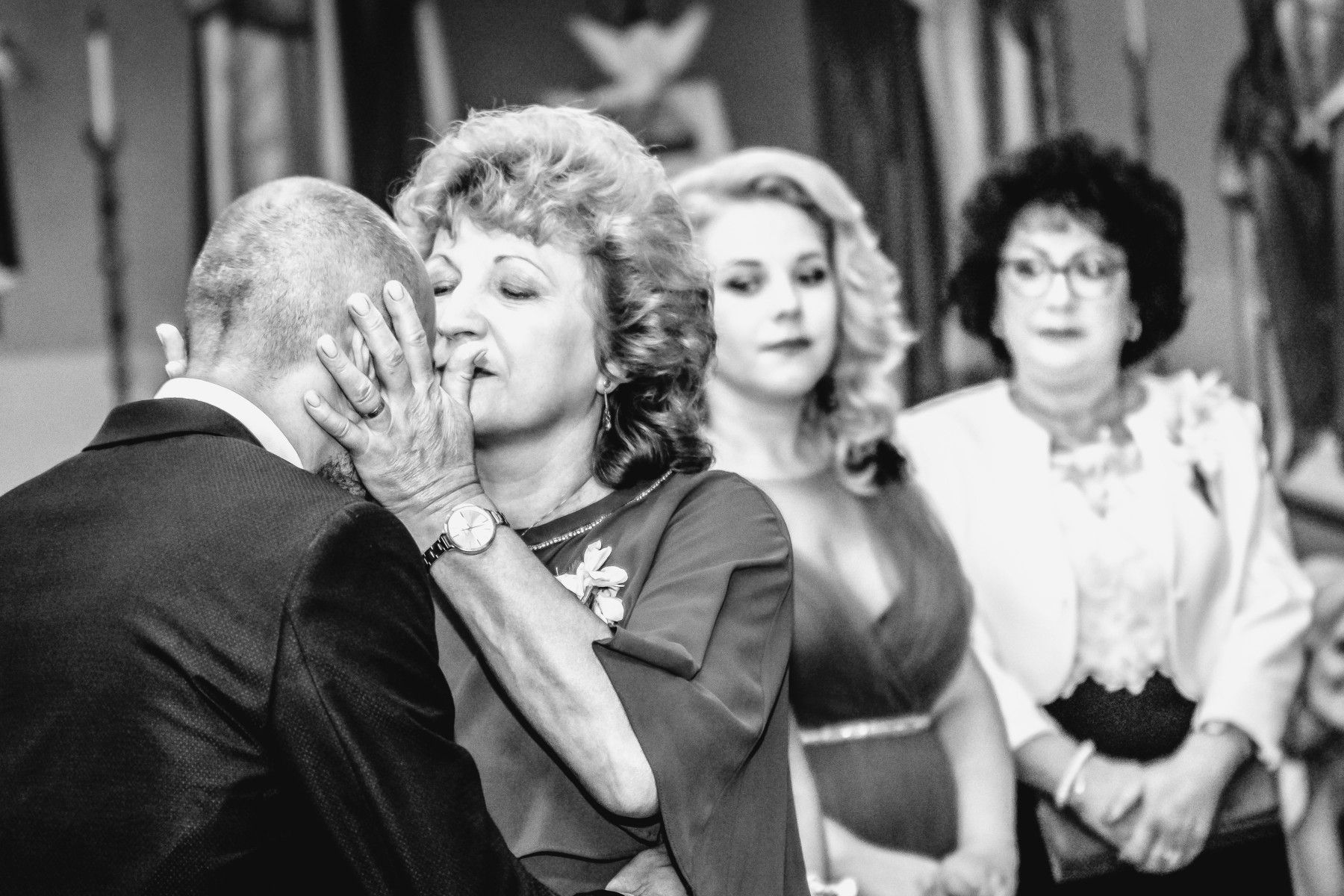 Mama își sărută fiul, iar ceilalți privesc